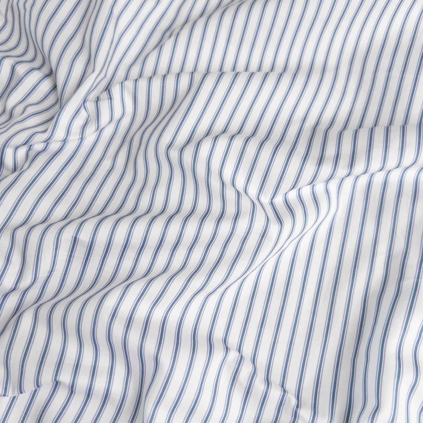 Close-up of navy ticking organic cotton waterproof fabric used in Little Human Linens fitted sheet, showing soft textured weave
