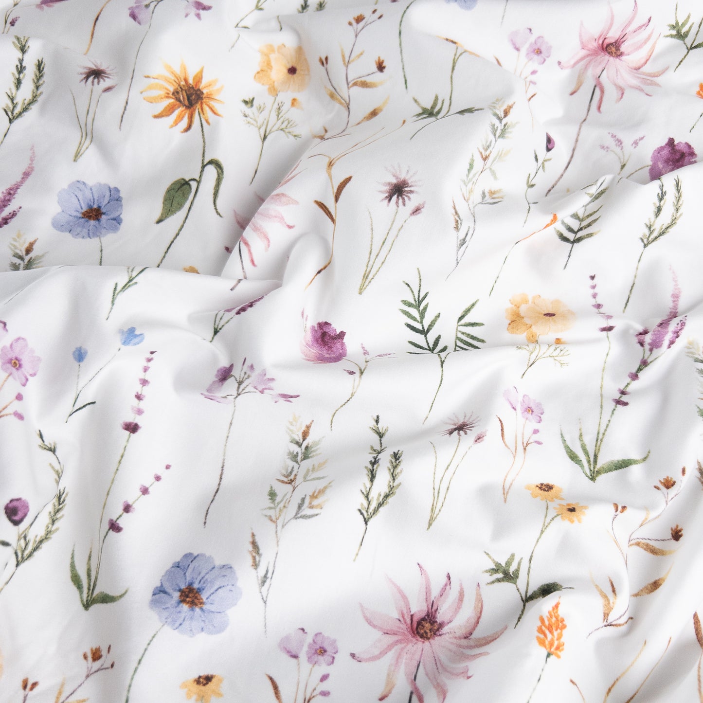 Close-up of wildflower organic cotton waterproof fabric used in Little Human Linens kids fitted sheet, showing soft textured weave