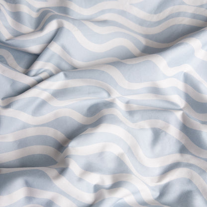 Close-up of bright waves organic cotton waterproof fabric used in Little Human Linens fitted sheet, showing soft textured weave
