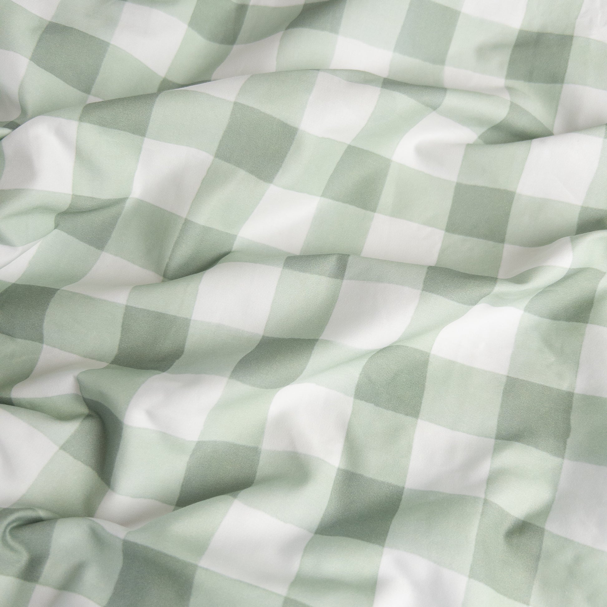 Close-up of green gingham organic cotton waterproof fabric used in Little Human Linens fitted sheet, showing soft textured weave