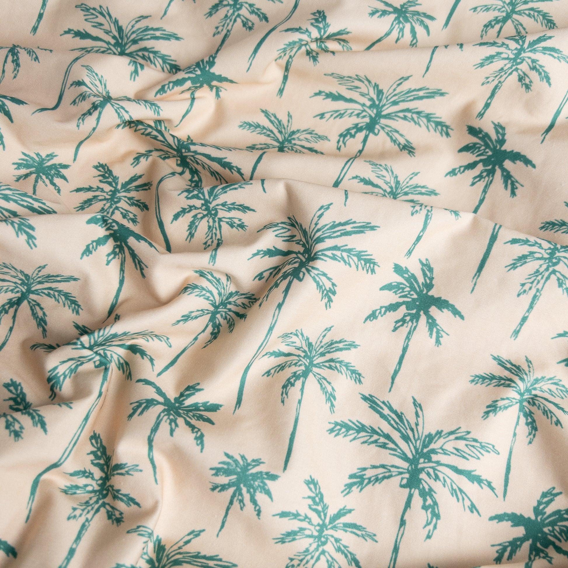 Close-up of green palms organic cotton waterproof fabric used in Little Human Linens fitted sheet, showing soft textured weave