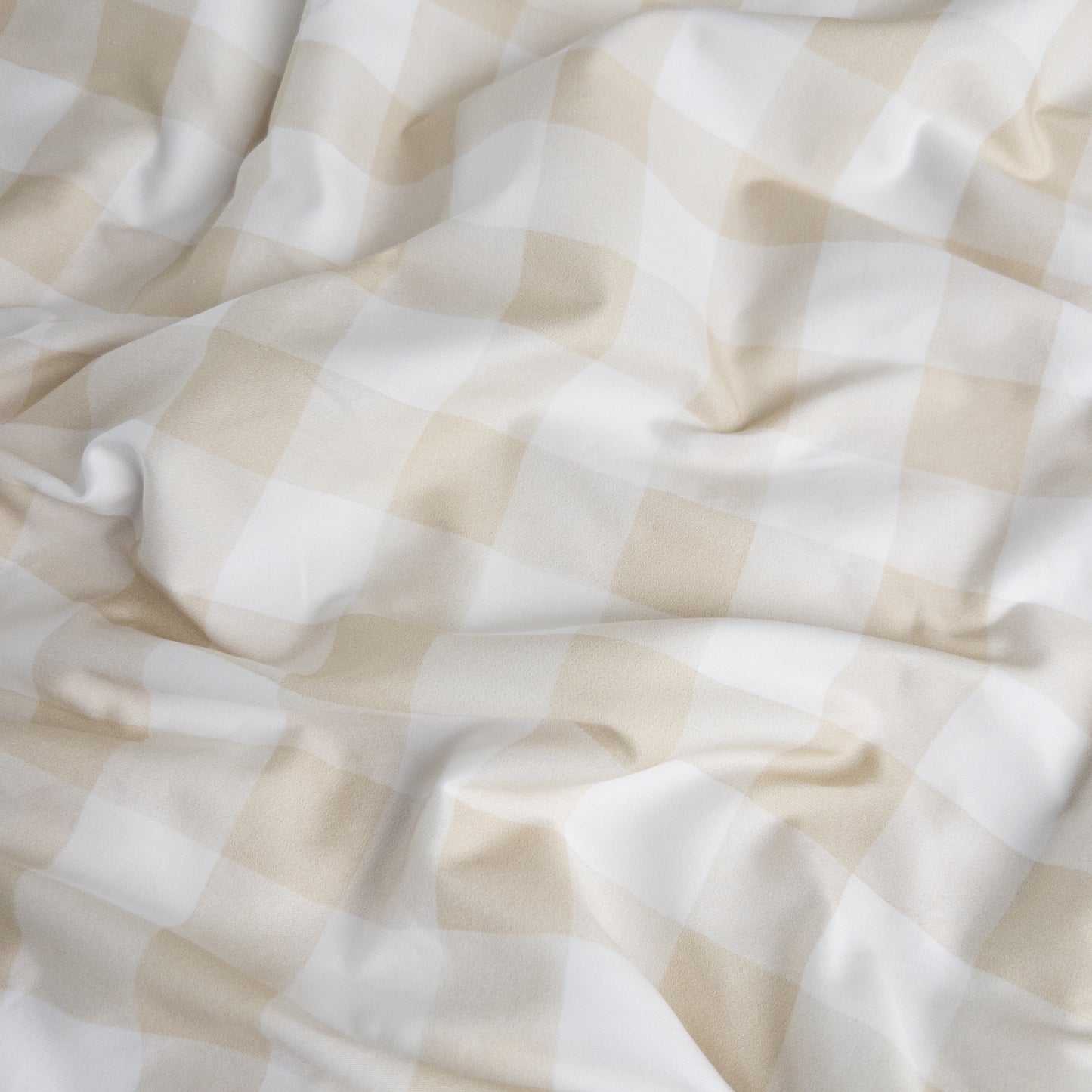 Close-up of latte gingham organic cotton waterproof fabric used in Little Human Linens fitted sheet, showing soft textured weave
