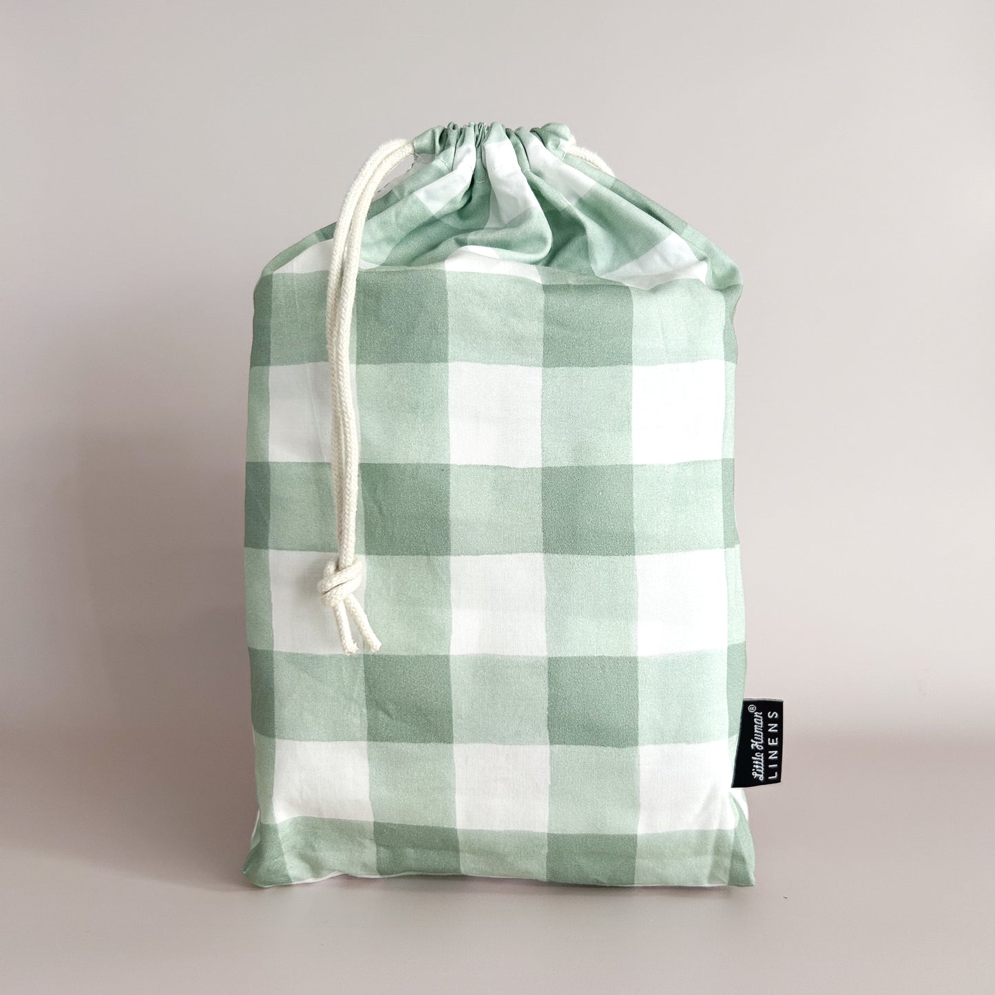 Little Human Linens Green Gingham mini cot waterproof fitted sheet in branded reusable packaging bag