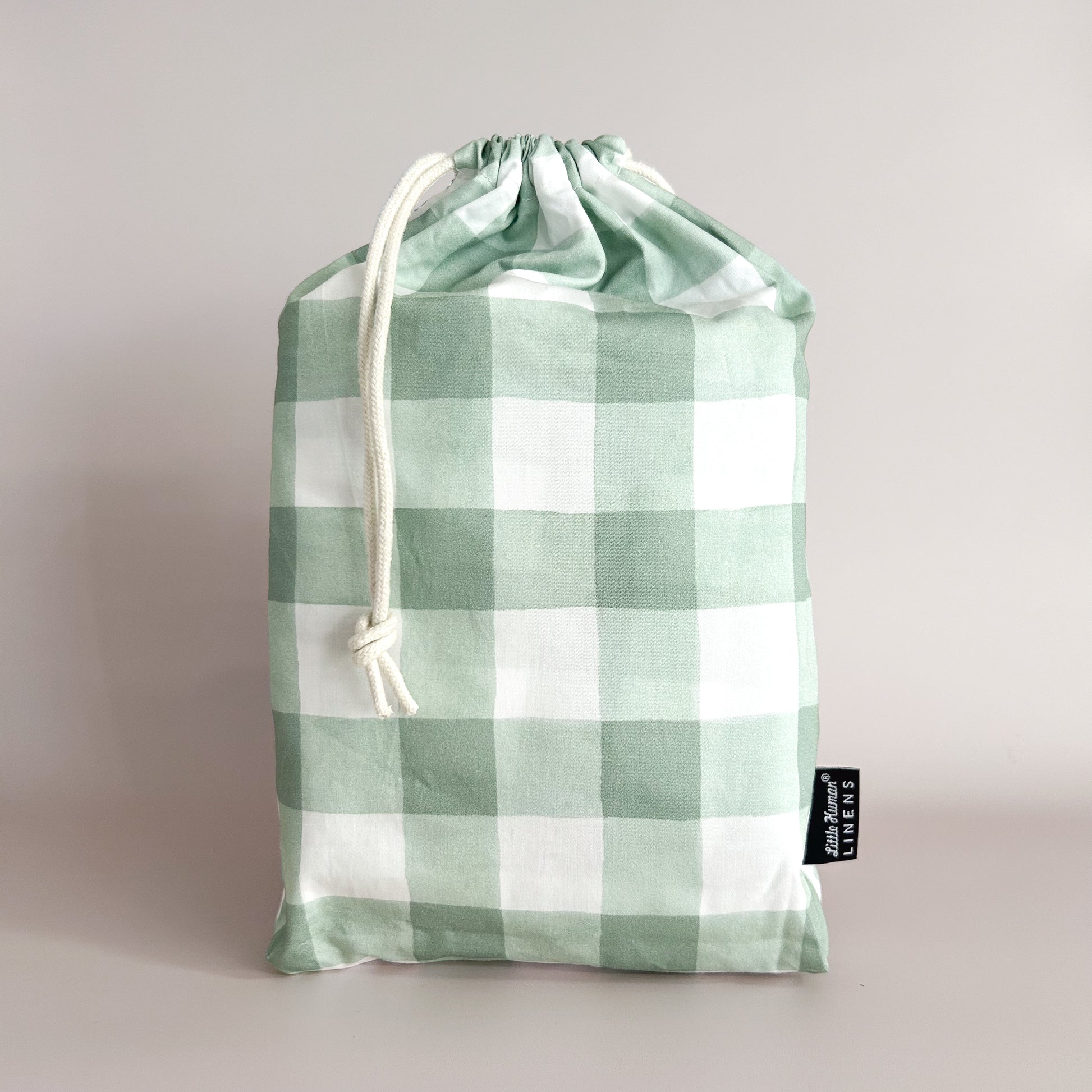 Little Human Linens Green Gingham mini cot waterproof fitted sheet in branded reusable packaging bag