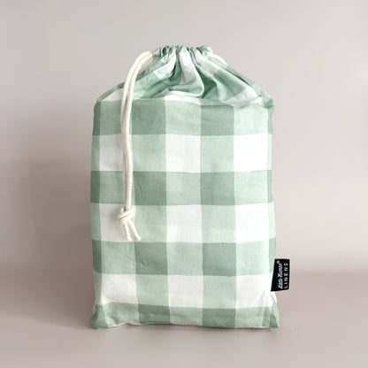 Little Human Linens Green Gingham mini cot waterproof fitted sheet in branded reusable packaging bag