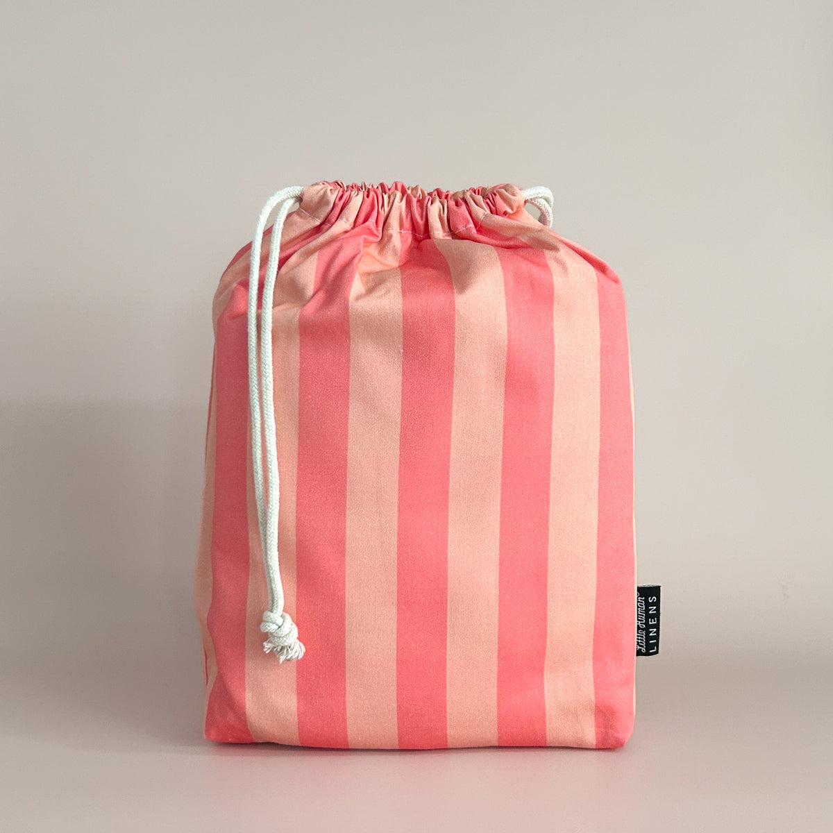 Little Human Linens Peach Candy mini cot waterproof fitted sheet in branded reusable packaging bag