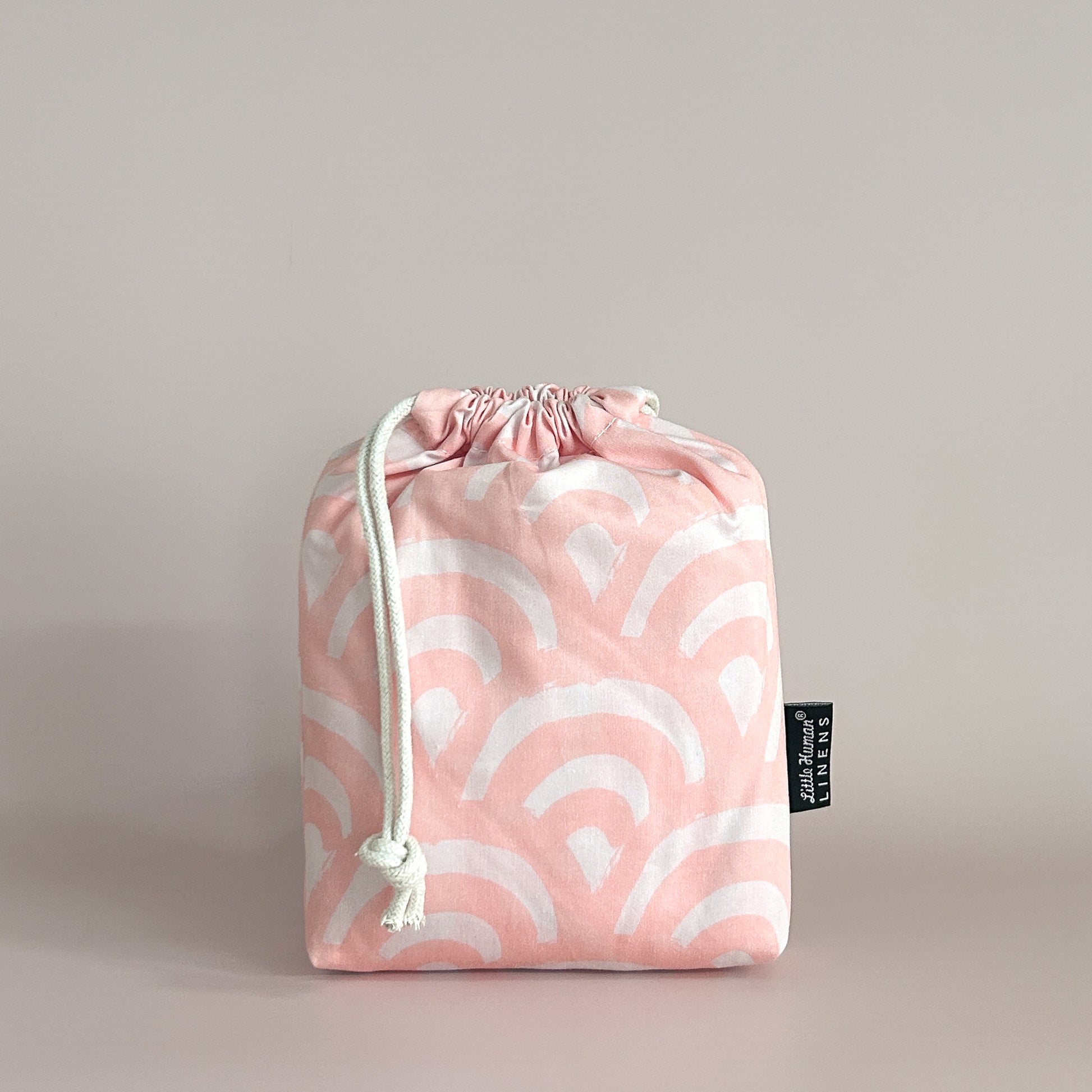 Little Human Linens Peach Rainbows small bassinet waterproof fitted sheet in branded reusable packaging bag