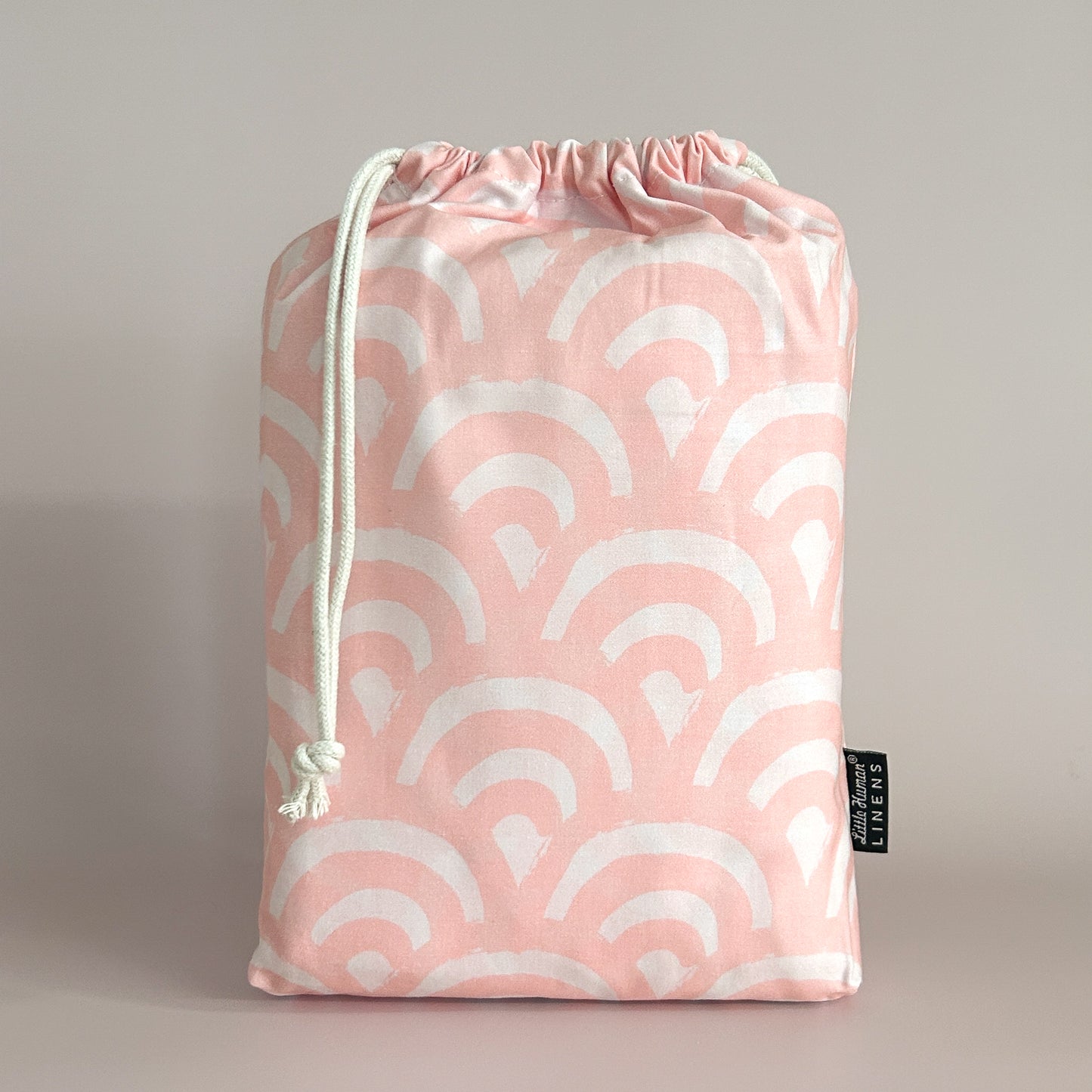Little Human Linens Peach Rainbows standard cot waterproof fitted sheet in branded reusable packaging bag