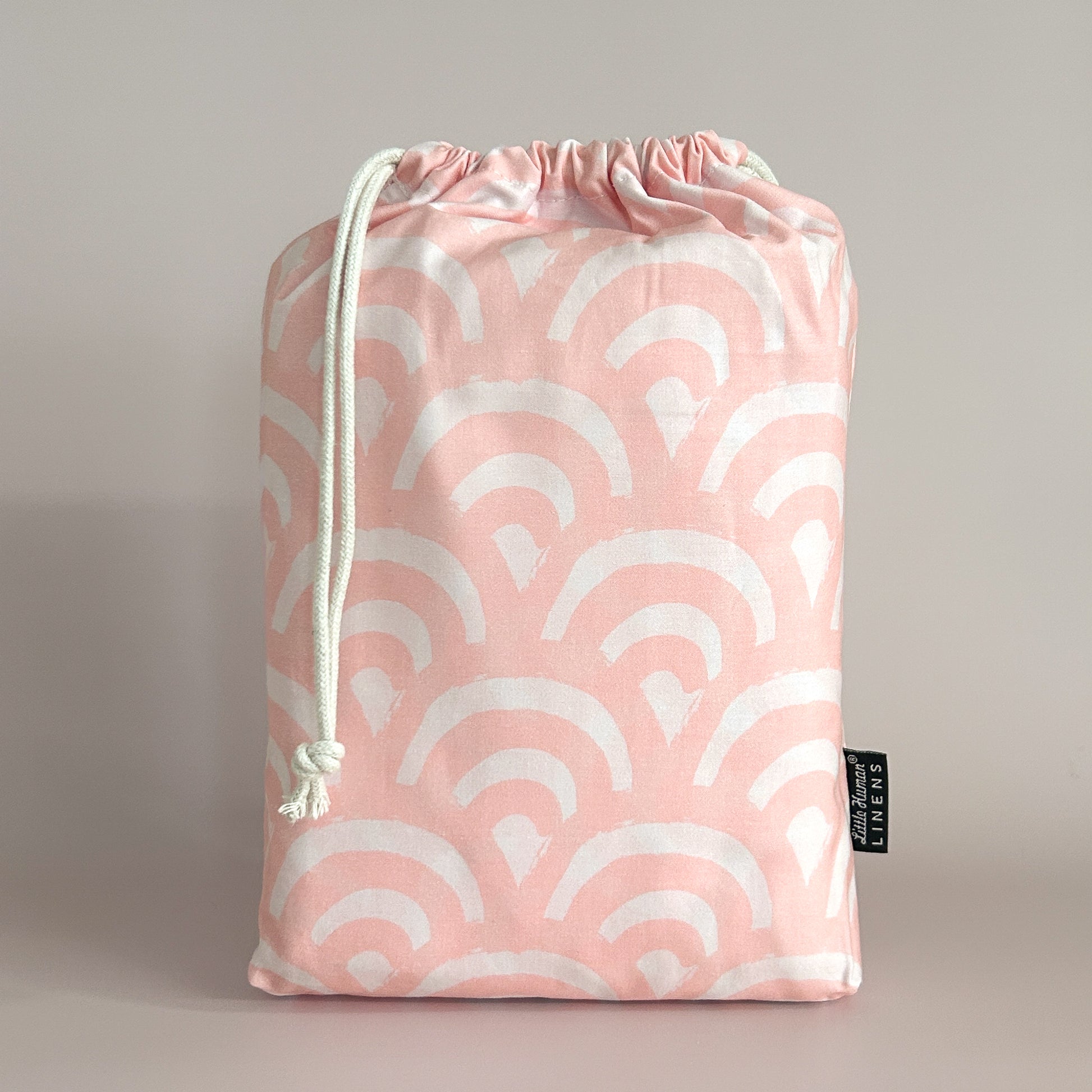 Little Human Linens Peach Rainbows standard cot waterproof fitted sheet in branded reusable packaging bag