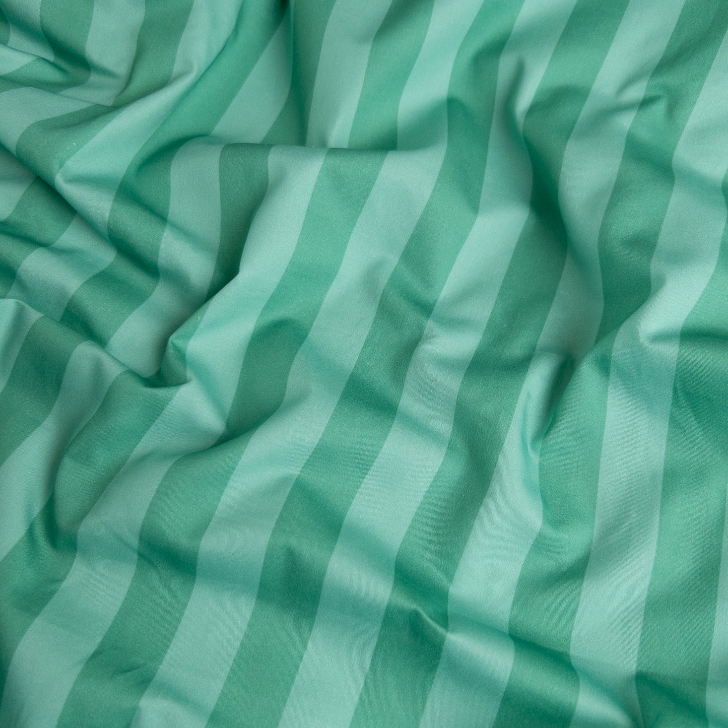 Close-up of mint candy organic cotton waterproof fabric used in Little Human Linens fitted sheet, showing soft textured weave