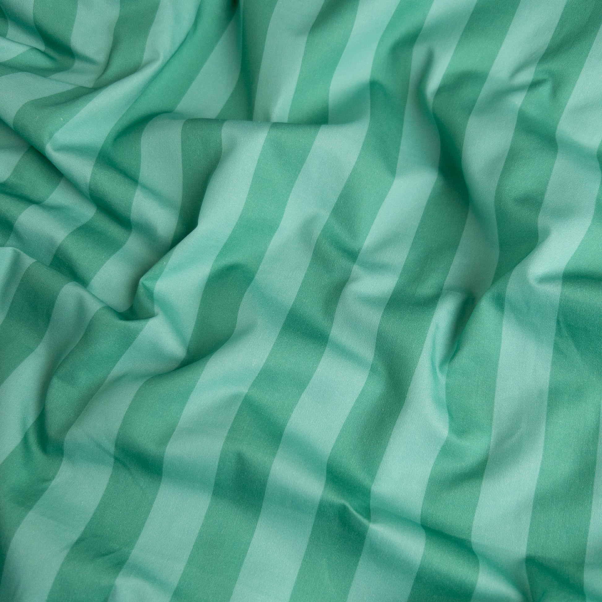 Close-up of mint candy organic cotton waterproof fabric used in Little Human Linens fitted sheet, showing soft textured weave