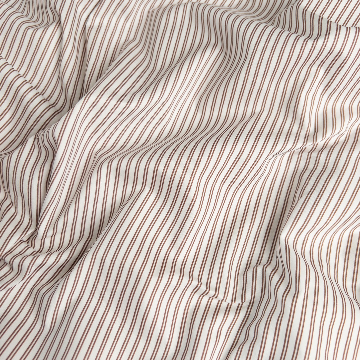 Close-up of mocha pinstripe organic cotton waterproof fabric used in Little Human Linens fitted sheet, showing soft textured weave