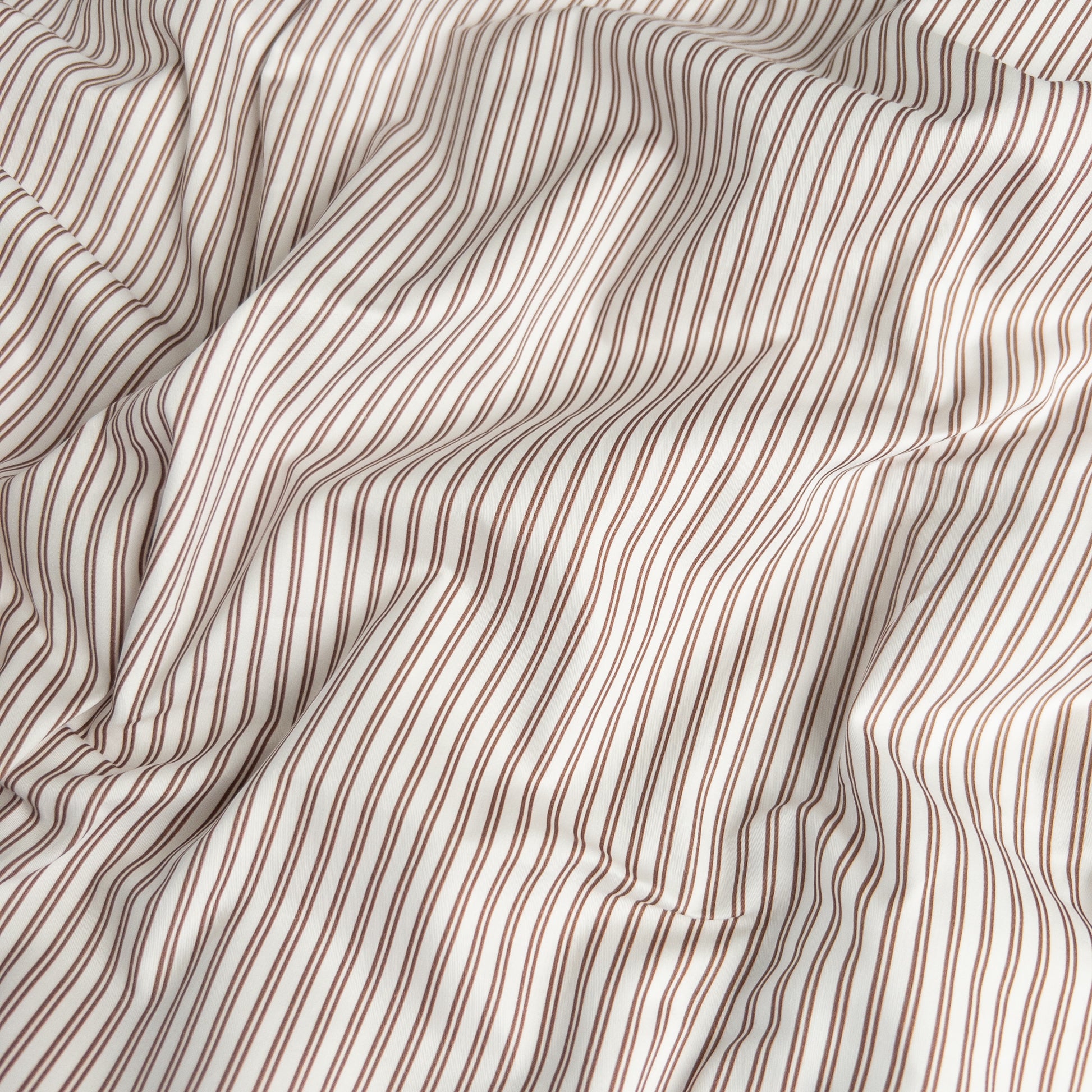 Close-up of mocha pinstripe organic cotton waterproof fabric used in Little Human Linens fitted sheet, showing soft textured weave