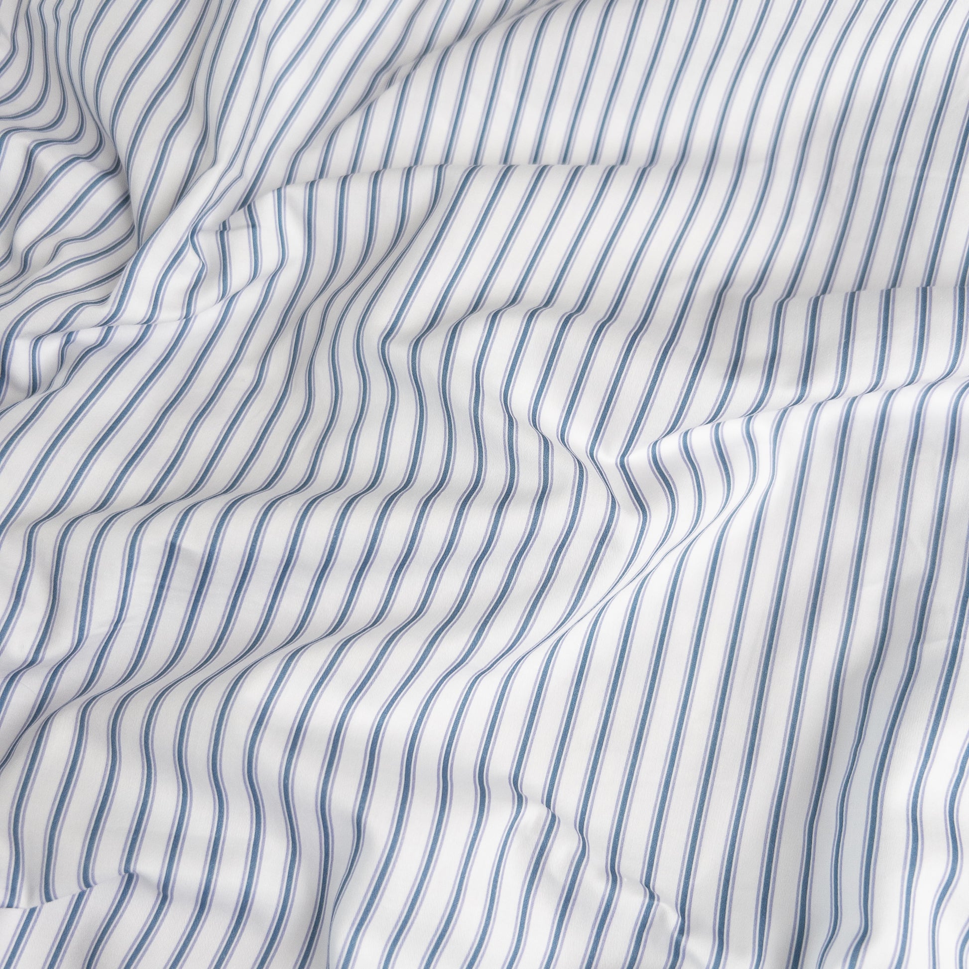 Close-up of navy ticking organic cotton waterproof fabric used in Little Human Linens fitted sheet, showing soft textured weave