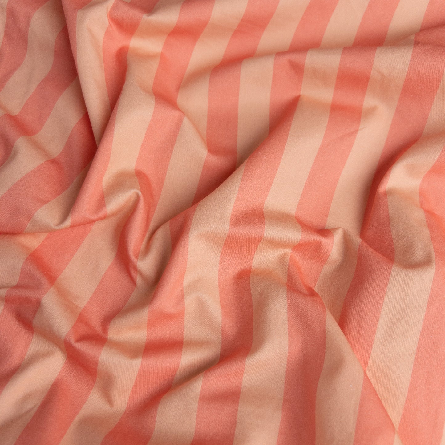 Close-up of peach candy organic cotton waterproof fabric used in Little Human Linens fitted sheet, showing soft textured weave