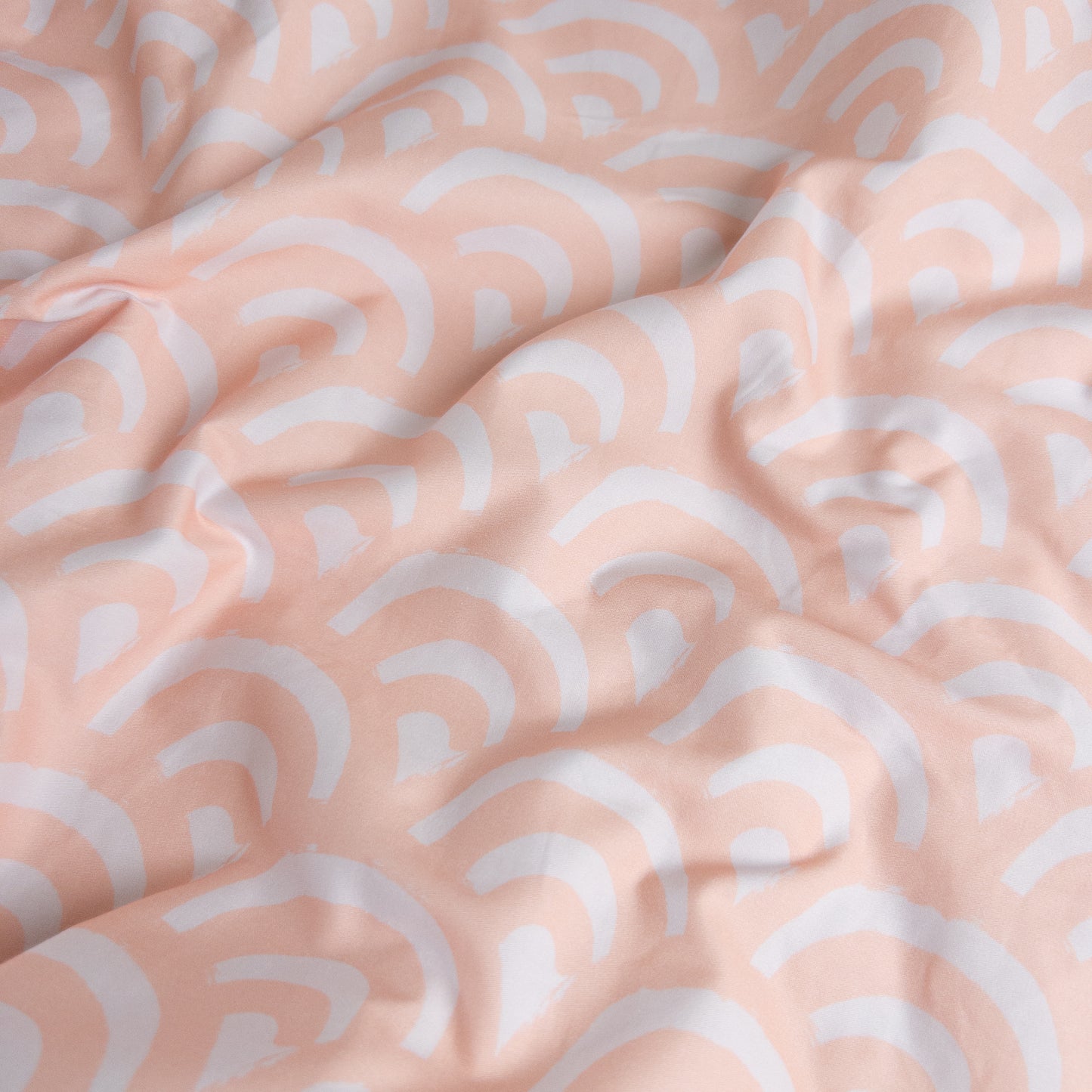 Close-up of peach rainbows gingham organic cotton waterproof fabric used in Little Human Linens fitted sheet, showing soft textured weave