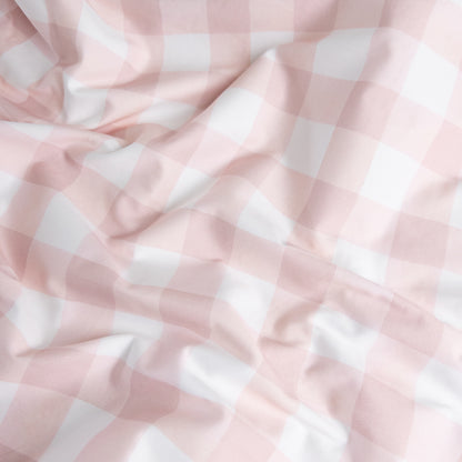 Close-up of pink gingham organic cotton waterproof fabric used in Little Human Linens fitted sheet, showing soft textured weave