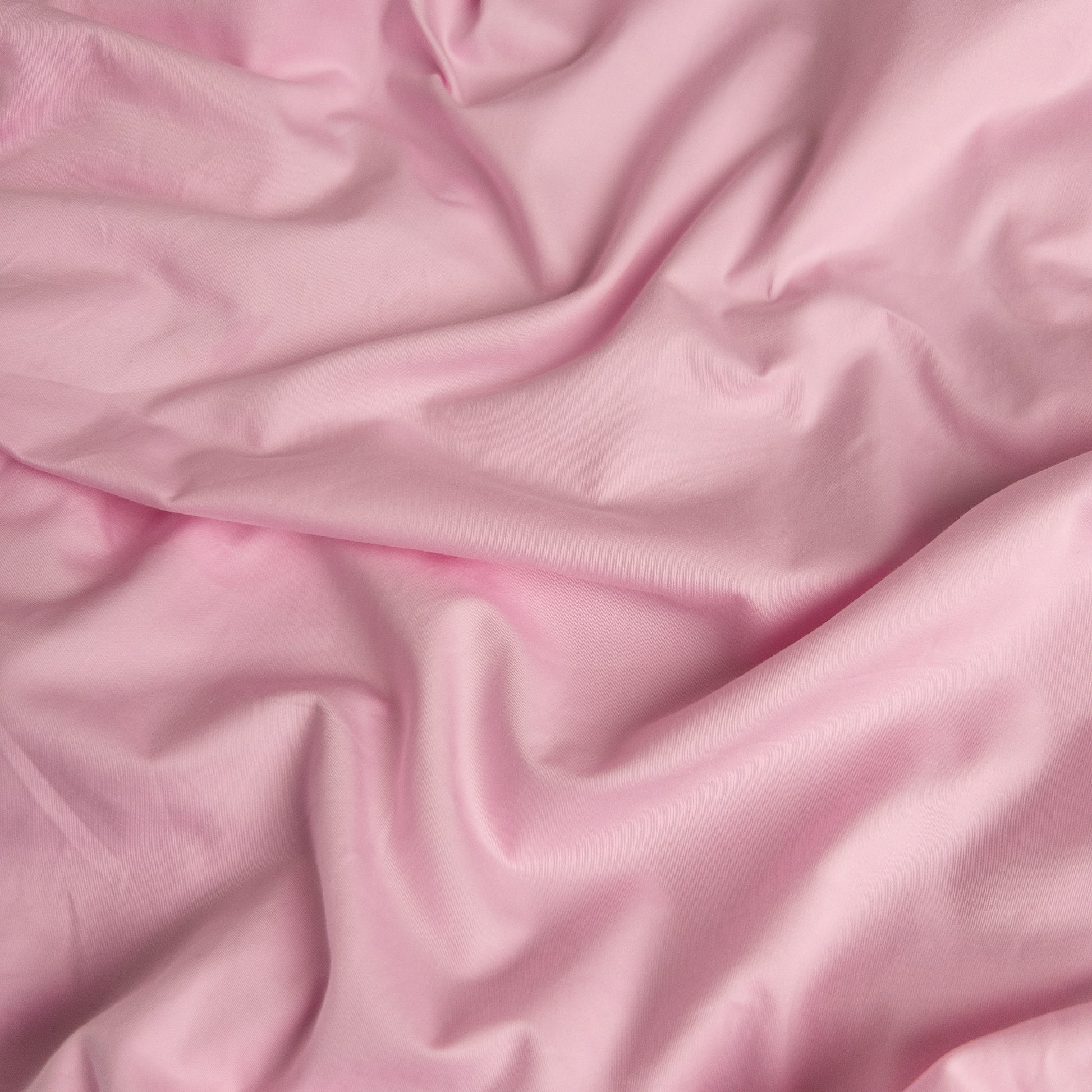 Close-up of pink organic cotton waterproof fabric used in Little Human Linens fitted sheet, showing soft textured weave