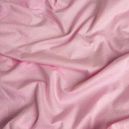 Close-up of pink organic cotton waterproof fabric used in Little Human Linens fitted sheet, showing soft textured weave